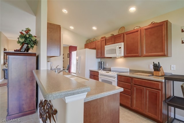 kitchen with white appliances, vaulted ceiling, a breakfast bar, sink, and light tile patterned floors