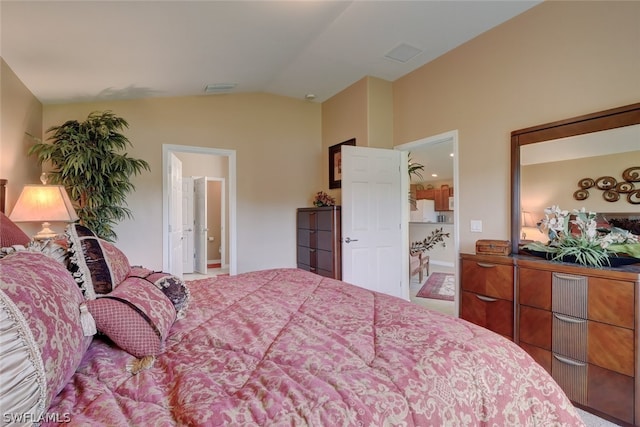 bedroom featuring lofted ceiling, carpet floors, and connected bathroom