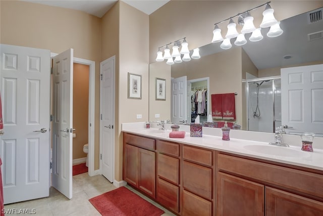 bathroom with toilet, double sink vanity, and tile patterned flooring