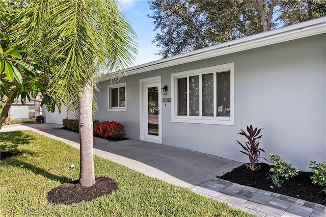 doorway to property with a yard and a patio area