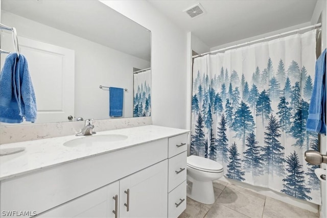 bathroom with vanity, tile patterned floors, and toilet