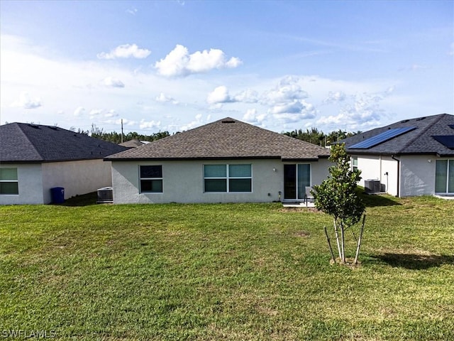 rear view of house featuring cooling unit and a yard