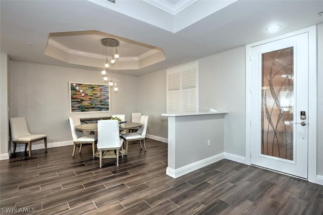 dining area with a tray ceiling and ornamental molding