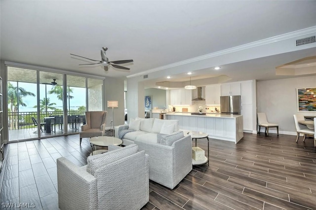 living room featuring crown molding and ceiling fan