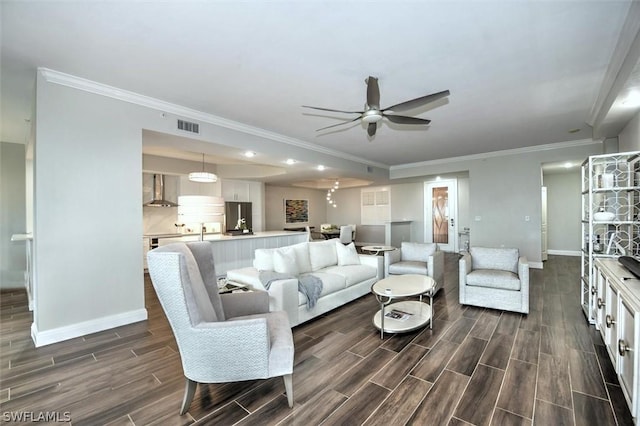 living room with ceiling fan and ornamental molding