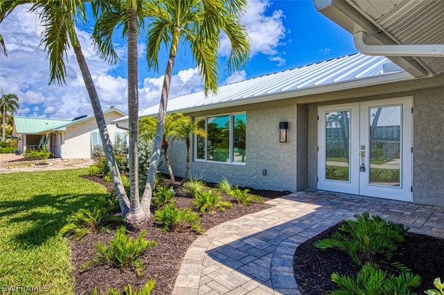 doorway to property featuring a yard and french doors