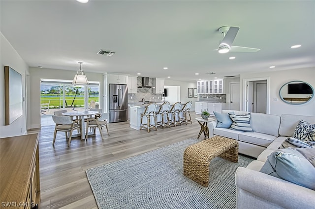 living room featuring light hardwood / wood-style flooring and ceiling fan