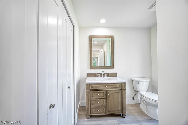 bathroom featuring hardwood / wood-style floors, vanity, and toilet