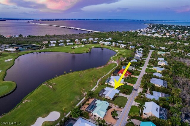 aerial view at dusk featuring a water view