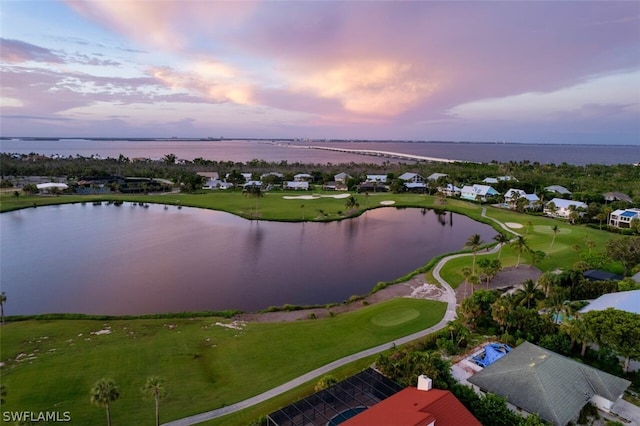 aerial view at dusk featuring a water view