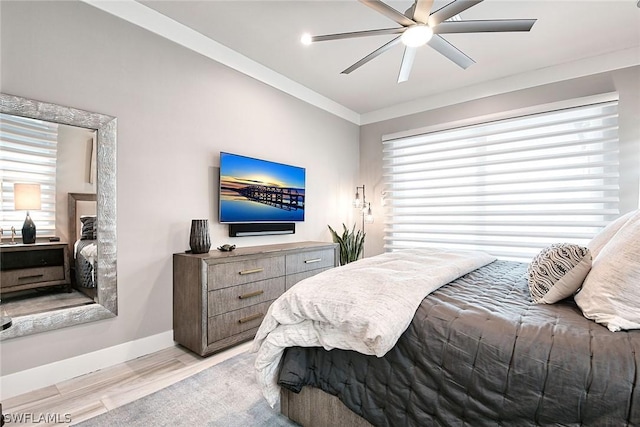 bedroom with ornamental molding, ceiling fan, and light hardwood / wood-style floors