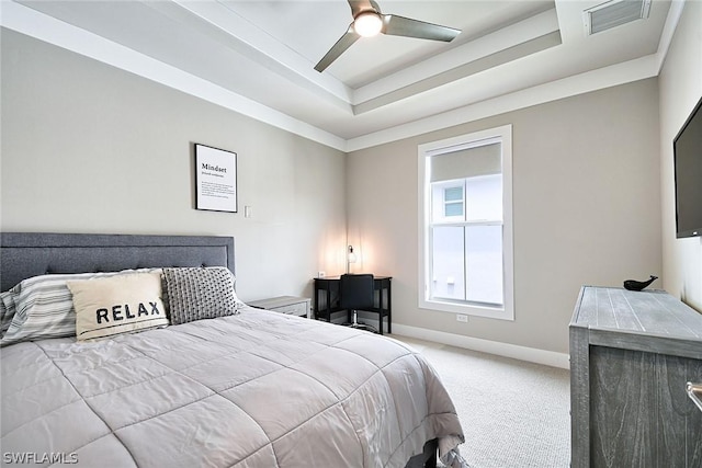 bedroom with carpet floors, ceiling fan, and a tray ceiling