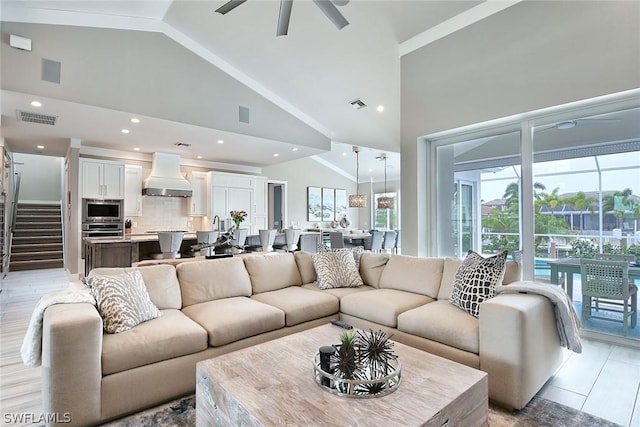 living room featuring ceiling fan and high vaulted ceiling