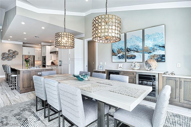 dining room with vaulted ceiling, light wood-type flooring, an inviting chandelier, and wine cooler