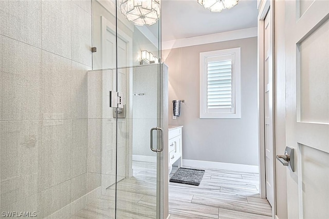 bathroom featuring an enclosed shower, a chandelier, and vanity