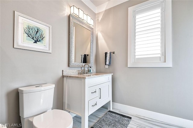 bathroom with toilet, wood-type flooring, and vanity