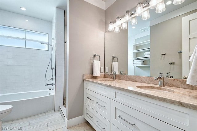 bathroom featuring toilet, a tile shower, and vanity