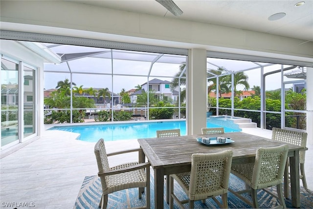 view of swimming pool featuring a jacuzzi, glass enclosure, and a patio