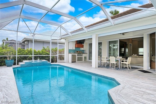 view of swimming pool featuring exterior kitchen and a patio area