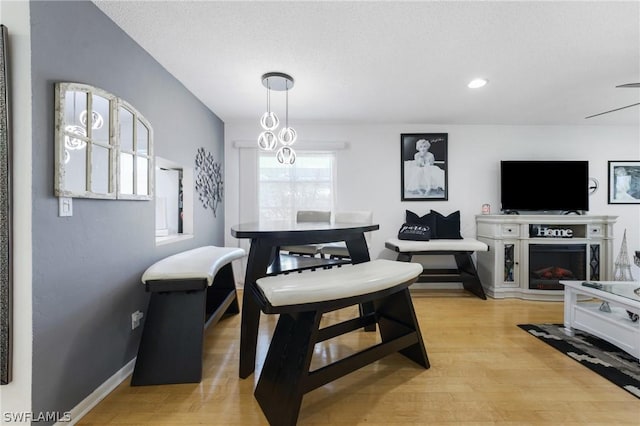 dining space featuring light wood-type flooring and a textured ceiling