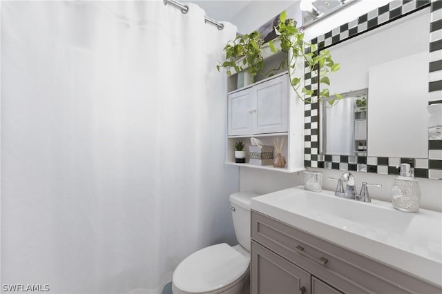 bathroom with vanity, toilet, and backsplash