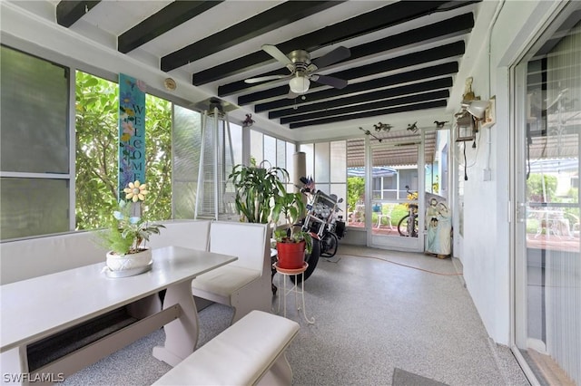 sunroom / solarium featuring beamed ceiling, ceiling fan, and a healthy amount of sunlight