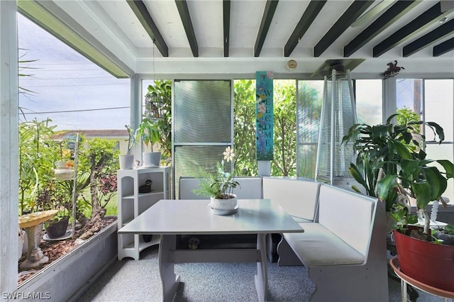 sunroom / solarium featuring beam ceiling and plenty of natural light