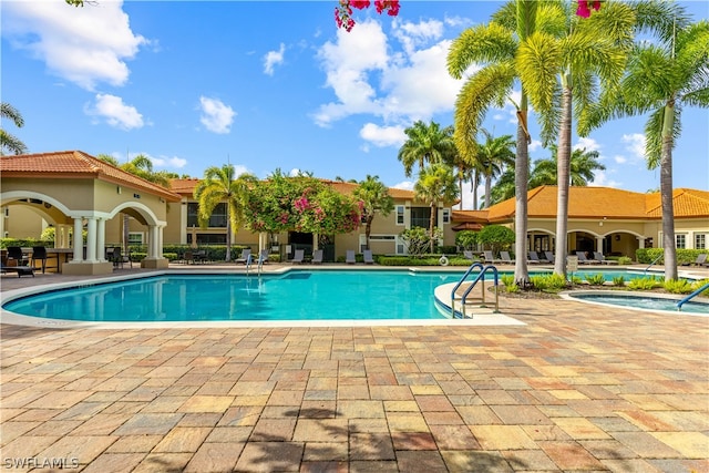 view of swimming pool with a patio area and a hot tub