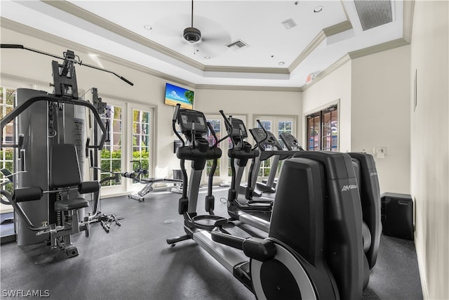 gym with french doors, ornamental molding, ceiling fan, and a tray ceiling