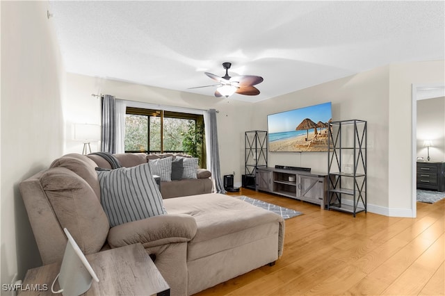 living room with hardwood / wood-style floors, a textured ceiling, and ceiling fan