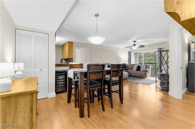 dining room featuring beverage cooler and light hardwood / wood-style flooring