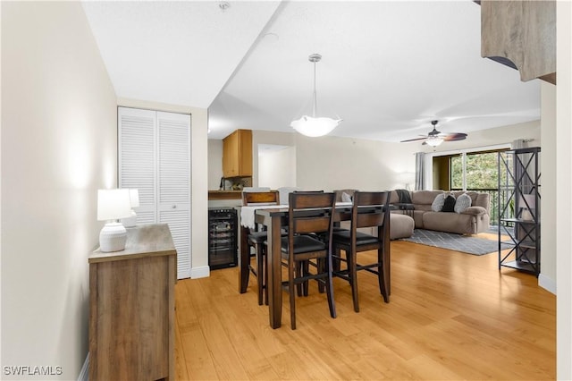 dining area featuring wine cooler and light wood-type flooring