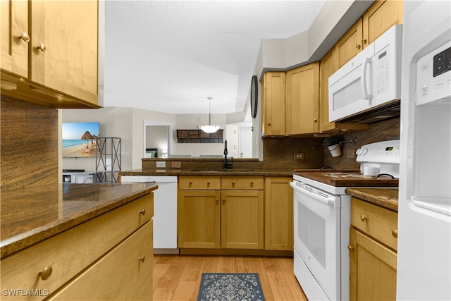 kitchen featuring pendant lighting, tasteful backsplash, sink, white appliances, and light hardwood / wood-style flooring