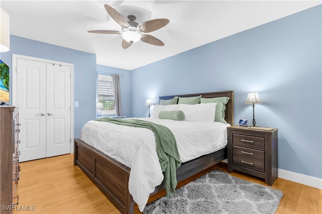 bedroom with light hardwood / wood-style flooring, a closet, and ceiling fan