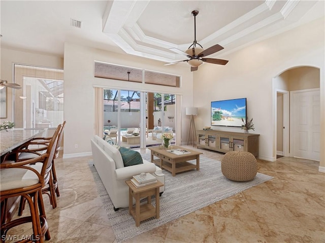 living room with ceiling fan, ornamental molding, and a raised ceiling