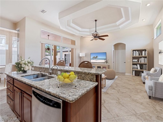 kitchen featuring light stone counters, sink, dishwasher, and a center island with sink