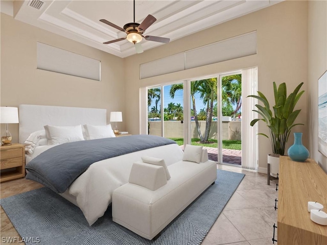 bedroom with ceiling fan, light tile patterned floors, a tray ceiling, and access to outside