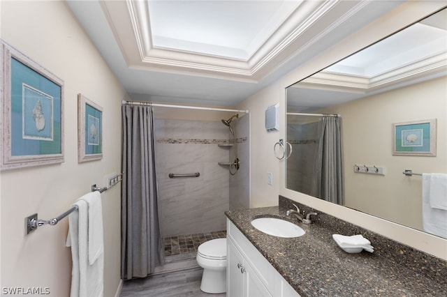 bathroom featuring a shower with shower curtain, vanity, a tray ceiling, crown molding, and toilet