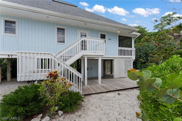 back of property with a sunroom and a wooden deck