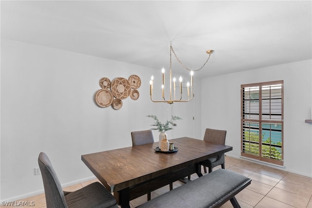 tiled dining room with a healthy amount of sunlight and a chandelier