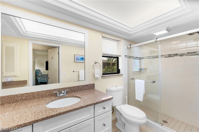 bathroom featuring toilet, a tray ceiling, vanity, a shower with shower door, and ornamental molding