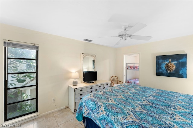 bedroom with a walk in closet, ceiling fan, and light tile patterned flooring