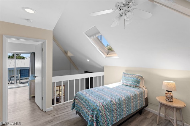 bedroom with wood-type flooring, lofted ceiling with skylight, and ceiling fan