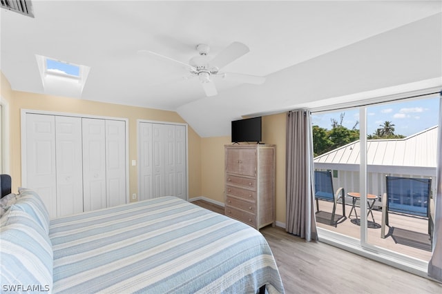 bedroom featuring lofted ceiling, light hardwood / wood-style flooring, ceiling fan, access to exterior, and multiple closets