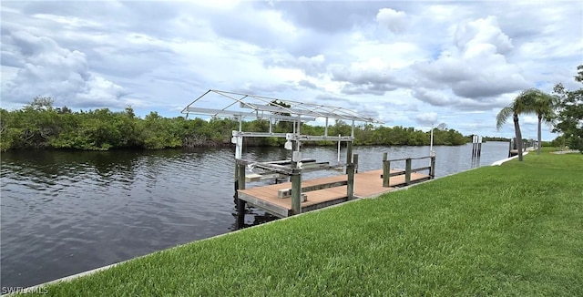 view of dock with a water view and a yard