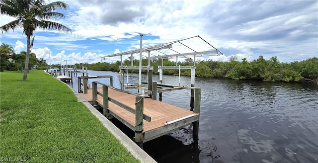 view of dock featuring a lawn and a water view