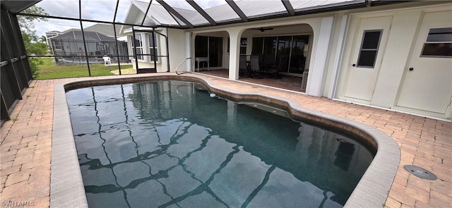 view of pool with glass enclosure and a patio