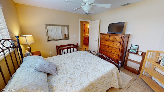 bedroom with light tile patterned flooring, ceiling fan, and ensuite bath