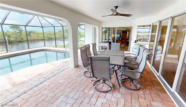 sunroom / solarium featuring a water view, ceiling fan, and a wealth of natural light