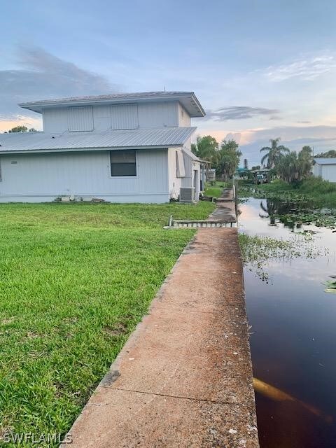 property exterior at dusk featuring a yard